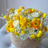 Yellow and white flower arrangement in a woven basket