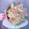 Large bouquet of pink and cream roses wrapped in pink paper