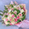 Bouquet of pink roses, white carnations, and daisies wrapped in pink paper