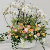 Large floral arrangement with white orchids and pink roses in a white vase