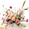 Pink and peach floral arrangement in a white box with a ribbon