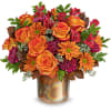 Orange roses and daisies in a metallic vase