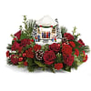 Christmas floral arrangement with red roses and a small nativity scene centerpiece
