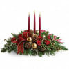Holiday centerpiece with three red candles, pinecones, and a red ribbon