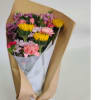 Bouquet of pink, purple, and yellow flowers wrapped in brown paper