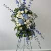 Tall floral spray with blue and white flowers on a stand