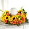 Sunflower and rose arrangement around a white urn