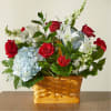 Basket arrangement of red roses, white lilies, and blue hydrangeas