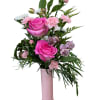 Pink roses and mixed blooms arranged in a tall pink vase