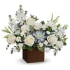 White roses and mixed white flowers in a wooden cube vase