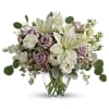 Lavender roses and white lilies in a clear glass vase