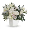 White roses and pale blooms arranged in a clear square vase