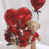 Red heart balloons with roses and a teddy bear in a pink box