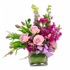 Pink roses and magenta flowers in a square glass vase with a striped ribbon