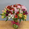 Mixed bouquet of colorful alstroemeria in a glass vase with a pink ribbon