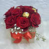 Red roses in a small box with a red ribbon and gold chocolates