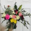 Mixed bouquet of roses, carnations, and chrysanthemums in a dark vase