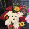 White teddy bear made of flowers with red roses and yellow blooms
