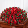 A beautiful casket full of red roses and touches of baby blue