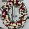 Large red and white floral wreath on a stand