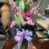 Pink roses and lilies in a glass vase with a pink ribbon and Mother's Day pick