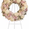 Pastel floral wreath on a white stand