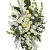White and pale yellow funeral spray on a black easel