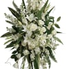 White floral standing spray with lilies and roses on a black easel