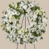 White floral wreath on a black stand