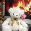 White teddy bear with a gold ribbon bow