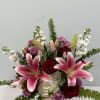 Pink lilies and red roses in a pink vase