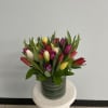 Colorful tulip bouquet in a striped glass vase
