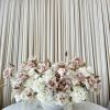 Large arrangement of pale pink and white roses in a white bowl vase