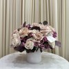 This picture-perfect arrangement of pink, white, and purple roses embodies the feeling