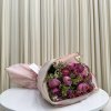 Bouquet of pink and purple flowers wrapped in pale pink paper