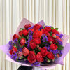 Bouquet of red roses with purple filler flowers in pink wrapping