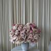 Large pink rose arrangement in a gray pedestal vase