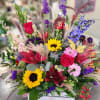 Colorful mixed bouquet with roses, lilies, sunflowers, and a butterfly accent