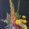Colorful mixed flower arrangement in a gray bowl vase