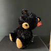 Black plush teddy bear with tan paws and muzzle