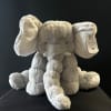 Gray plush elephant toy with oversized ears and a hanging tag