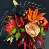 Halloween bouquet with a spider decoration and orange lilies