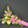 Pink lilies and roses arranged with a memorial ribbon