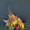Colorful floral arrangement in a woven horn-shaped container