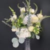 An elegant silver vase with a etched cross design is filled with
