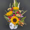 Sunflower arrangement in a white pumpkin container with mixed blooms and grasses