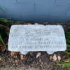 Memorial stone with engraved text in a garden bed