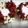 Two large floral wreaths of red and white roses on stands