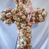 Cross-shaped floral arrangement of pink and peach roses