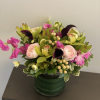 Pink and purple floral arrangement in a green vase